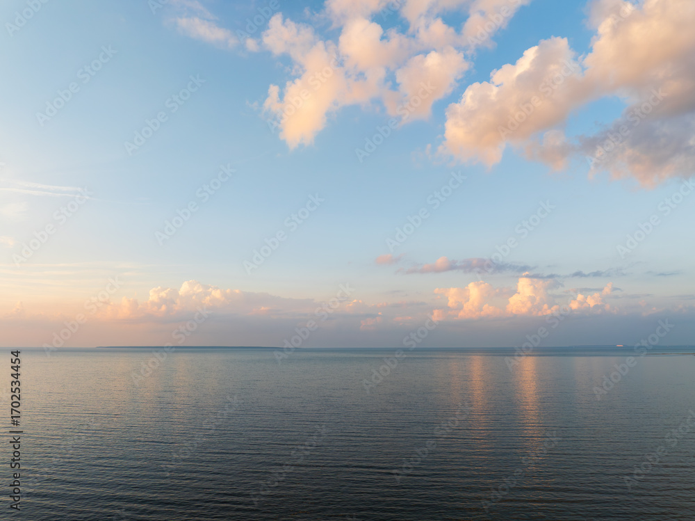 Obraz premium A peaceful aerial drone shot over the calm Baltic Sea in Estonia during a beautiful pastel-colored sunset or sunrise.
