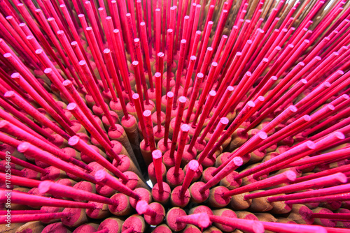 Bright pink incense sticks dry under the sun in Xianxi, Changhua, Taiwan. Traditional handmade incense creates a colorful display against a rustic backdrop.