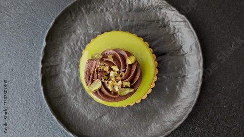 Pistachio cake or tart topped with green mousse with nuts and fruit filling. Pistachio pie as a food background for your design