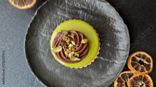 Pistachio cake or tart topped with green mousse with nuts and fruit filling. Pistachio pie as a food background for your design