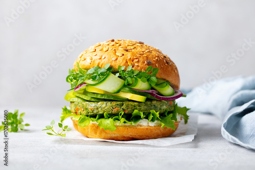 Healthy vegan burger with vegetables patty on a white parchment paper. Grey background. Close up.