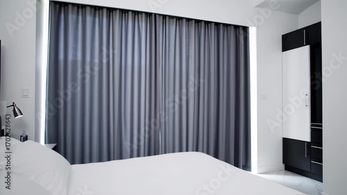 Simple bedroom with gray curtains and white bed