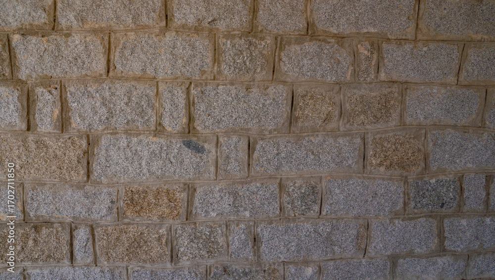 Fototapeta premium Rustic stone wall with multicolored natural rocks and mortar