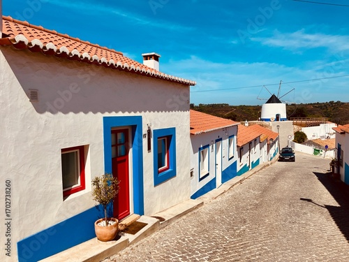 Maison traditionnelle blanche et bleue avec porte rouge à Odeceixe, Algarve, Portugal – architecture pittoresque méditerranéenne