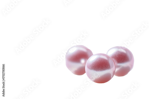 Three lustrous, pink pearls cluster gently against a dark background