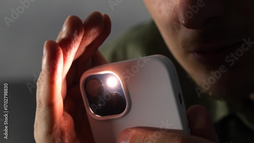Bright light from a smartphone's flashlight.
The flashlight illuminates a person and a dark room.
Close-up of a person lighting their way with a smartphone's flashlight.
Shine, smartphone, bright