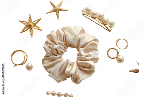 Cream-colored silk hair tie and gold jewelry accents, including starfish and pearls, arranged on a black background