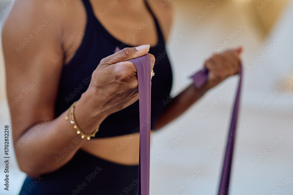 Obraz premium Close up of a woman exercising with a resistance band, promoting fitness and healthy lifestyle