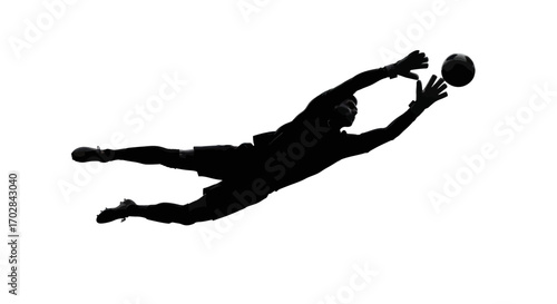 Silhouette of a goalkeeper dynamically diving to intercept the approaching football with intense