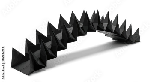 Abstract black origami sculpture casting shadow on a clean white surface aesthetic composition