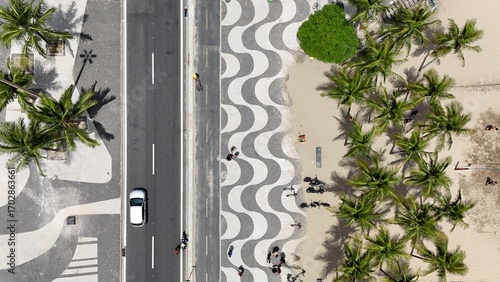 Foto Top-down aerial of the Copacabana Mosaic Sidewalk in Rio de Janeiro, with its iconic black and white wave design, palm trees, beach sand, and busy road