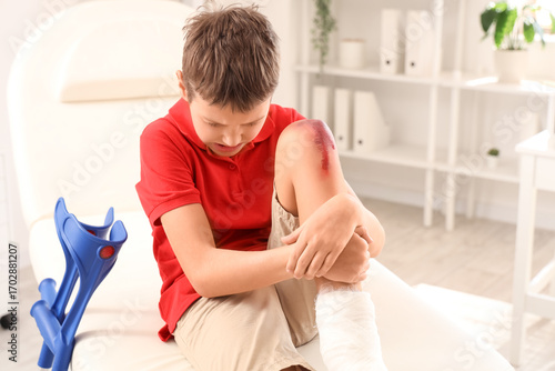 Little boy with wounded kne...