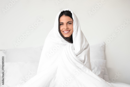 Morning of beautiful woman with blanket sitting in bedroom