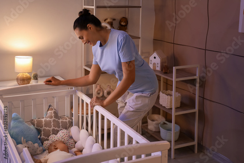 Happy young mother near cri...