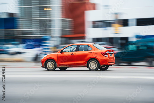 Orange car moving fast on city road