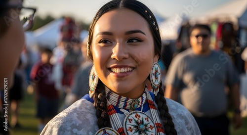 Smiling Indigenous woman in traditional regalia at a cultural festival.