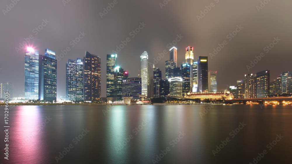 Fototapeta premium Modern city skyline at night with illuminated skyscraper reflection on calm water, serene urban mood