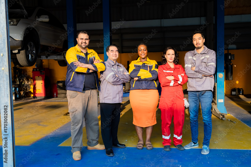 Obraz premium Group of diverse mechanics standing together in workshop showing thumbs up, teamwork in garage small business, partnership and multicultural collaboration reflecting trust in automotive industry