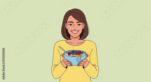 Smiling woman in yellow shirt holds blue bowl of oatmeal with berries and honey on light green background