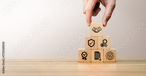 Принти на полотні Hand stacking wooden blocks with quality, certification, and ISO icons, symbolizing business standards, process management, quality assurance, compliance, trusted partnership for sustainable growth