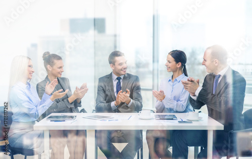 business team with laptop clapping hands
