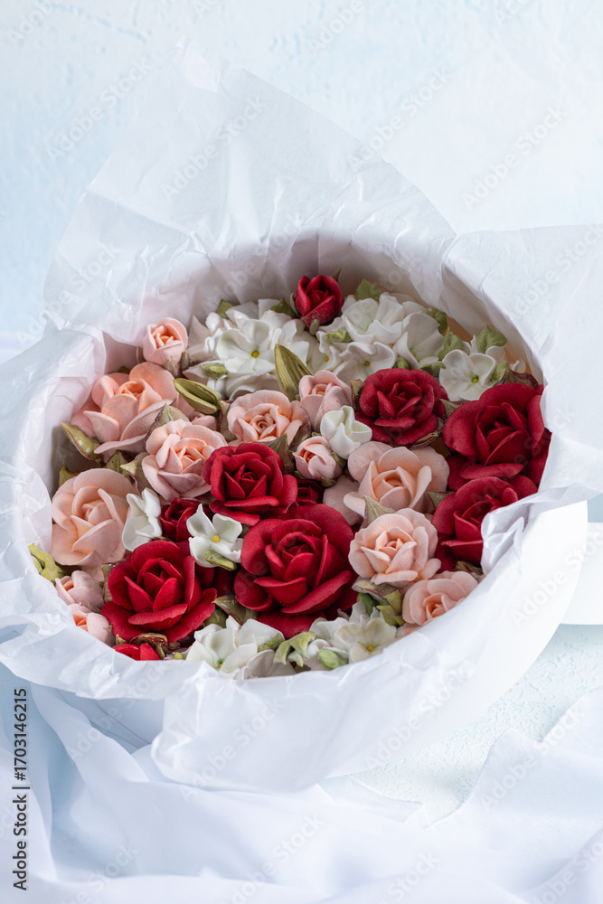 Fototapeta premium Beautiful arrangement of marshmallow flowers in a white round box, featuring vibrant red, soft pink, and delicate white blooms, showcasing unique floristry concept with copy space