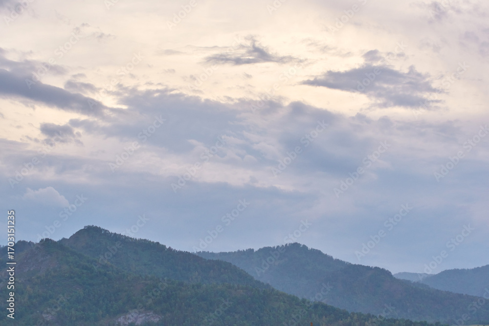 Obraz premium Serene cloudy sky over peaceful mountain range at dusk captured in tranquil scenic nature landscape.