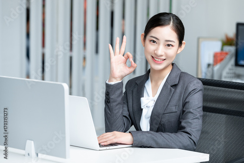 Portrait of a Smiling Female Businesswoman Making an OK Gesture
