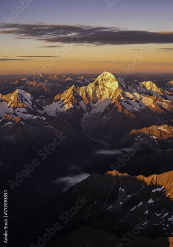 Majestic Golden Hour Over Snow-Capped Mountain Range with Dramatic Peaks and Valleys at Sunset, an Awe-Inspiring Alpine Landscape