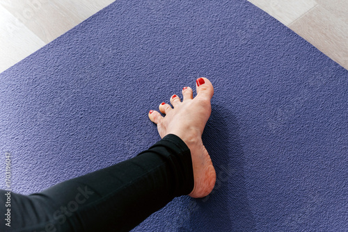 Bild auf Leinwand Yoga woman stretching feet spreading her toes doing toe stretch on exercise mat