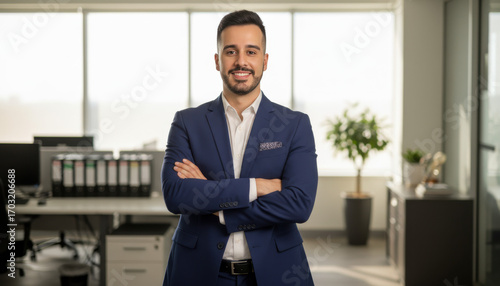 Confident leader smiling latin hispanic, middle eastern business man standing arms crossed in office looking at camera. Portrait of manager executive CEO entrepreneur