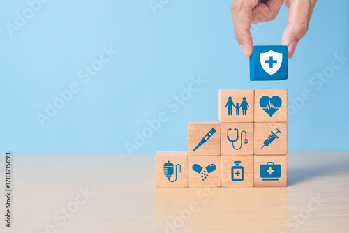 Hand holding wooden blocks, health insurance concept, medical wooden blocks with icons, health and access to health benefits concept