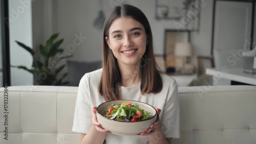 Fresh Garden Delight: A young woman beams with healthy vibrancy, holding a bowl brimming with a colorful garden salad, offering a tantalizing glimpse into a wholesome lifestyle.