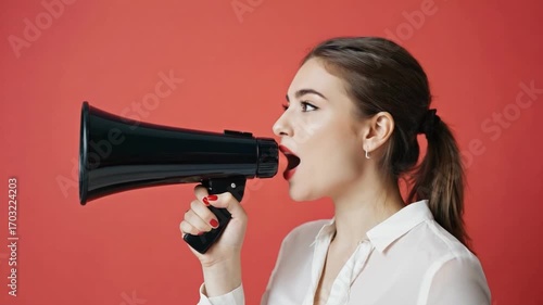 Expressing Loudly: An evocative studio portrait capturing a dynamic young woman amplifying her voice using a classic megaphone, standing against a vivid backdrop.