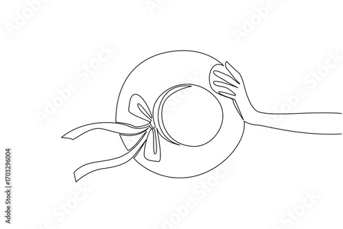 Single one line drawing hand holding straw hat with ribbon. Unique accessories and add a beautiful impression to women. Have a nice holiday. Straw Hat Day. Continuous line design graphic illustration