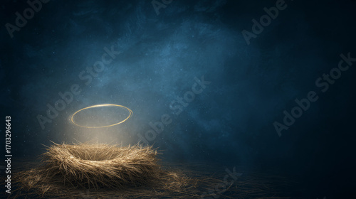 Symbolic nativity scene: empty wooden manger on straw with soft golden halo