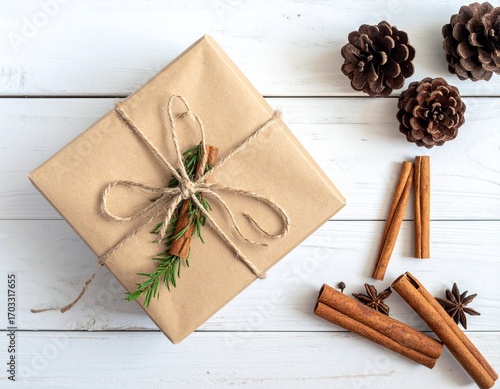 Rustic Christmas present wrapped in brown paper on a white table.

