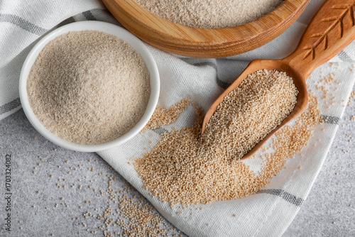 Raw organic amaranth grain and amaranth flour. Amaranth seeds in a wooden bowl on a table.