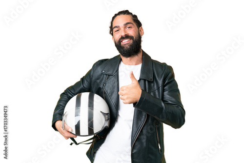 Young man with beard with a motorcycle helmet over isolated chroma key background giving a thumbs up gesture