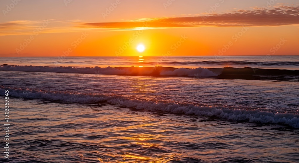 Fototapeta premium A vibrant sunrise paints the ocean with hues of orange and gold, showcasing a tranquil morning on the shoreline.