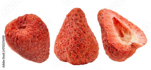 Three pieces of dried strawberries, one whole, one pointy, and a cross-section, showcasing their porous, crunchy texture and vibrant red color.