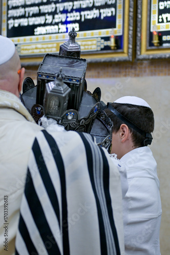A Bar Mitzvah boy and his father standing by the Torah ark