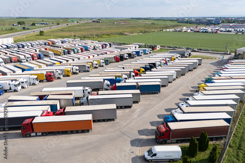 Aerial view of a large truck parking lot at a logistics hub, with multiple commercial semi trucks parked in organized rows
