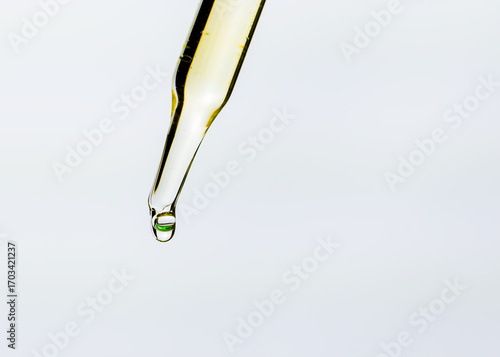 Close up view of glass pipette droplets on white background.