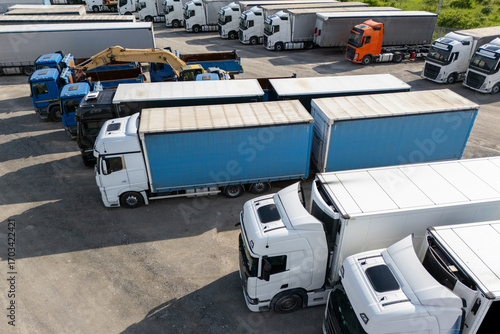 Aerial view of a large truck parking lot at a logistics hub, with multiple commercial semi trucks parked in organized rows