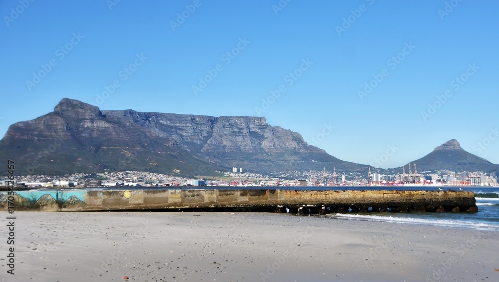 Naklejka premium Landscape with the beach and Table Mountain across the sea in morning light
