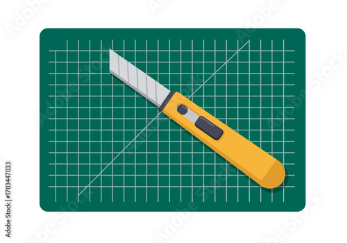 A yellow utility knife rests on a green cutting mat with a grid
