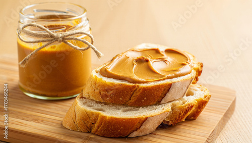 A jar of creamy peanut butter next to slices of bread, perfect for a delicious and easy snack.