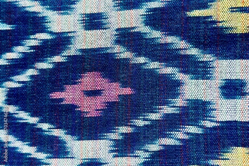 Handwoven ikat textile featuring colorful geometric patterns. Perfect for backgrounds, fashion, interior design, and cultural themes.