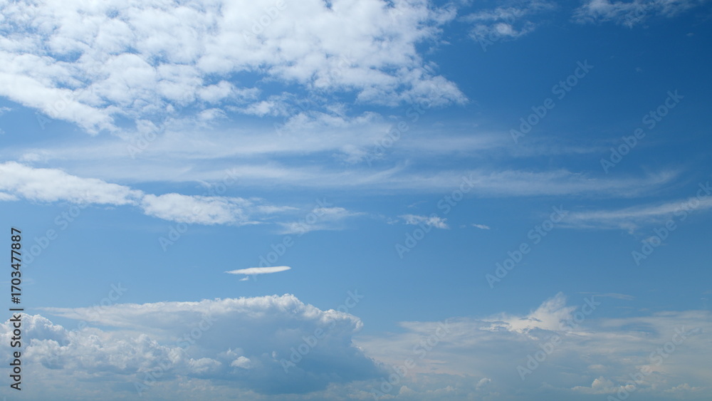 Fototapeta premium A Beautiful Blue Sky filled with Fluffy Clouds drifting gracefully in the atmosphere